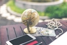 gray desk glove above U.S dollar beside iPhone and white airpods