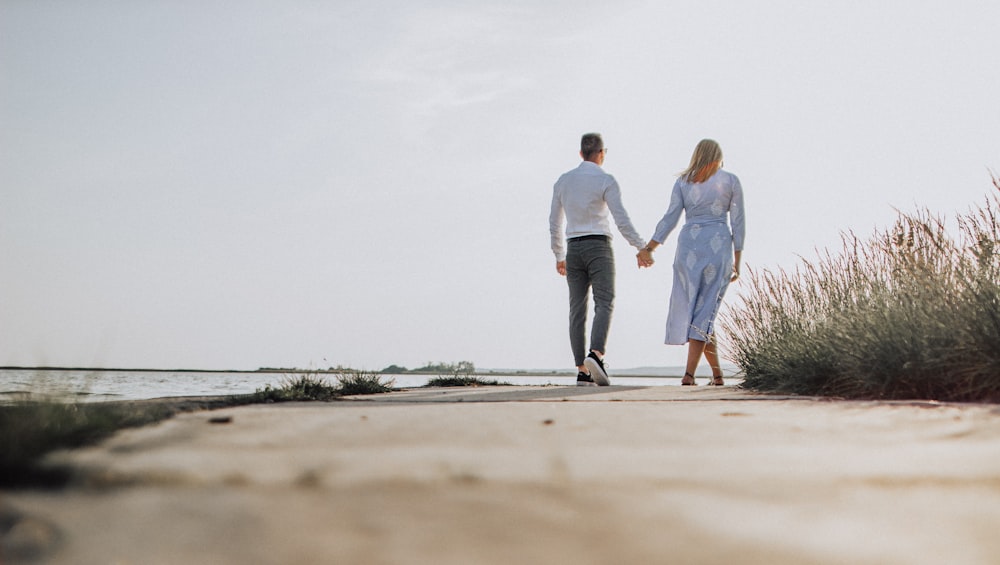couple holding hands with standing on shore