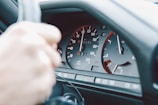 Close-up of hands using diagnostic tools on a vehicle dashboard.