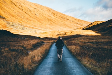 man walking on road photo