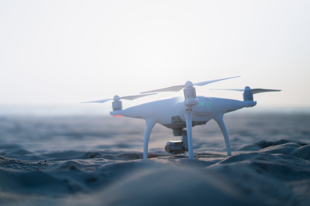 drone branco DJI Phantom na areia