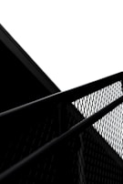 Shiny black metal fence panels being aligned perfectly between stone pillars at a property entrance.