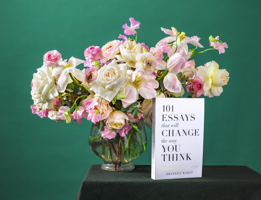 beige and pink petaled flowers in clear glass vase