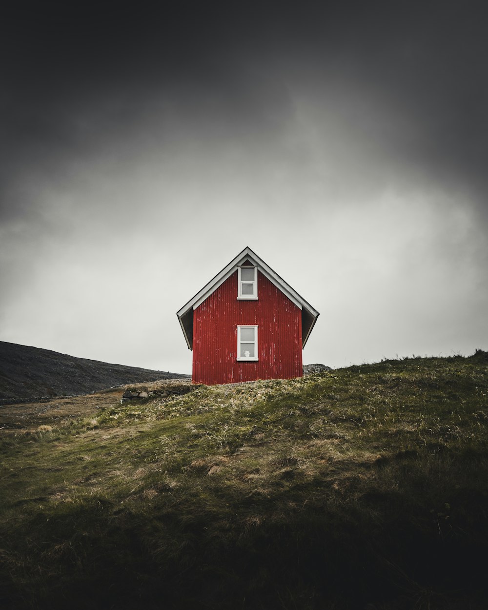 丘の上にある赤い納屋の家の写真