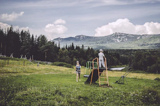 A warm, inviting photo of children playing outdoors under a bright blue sky.