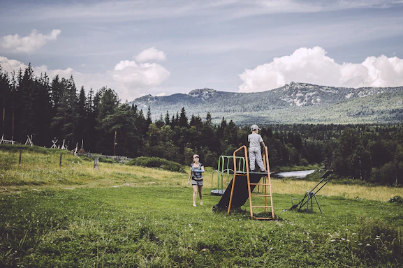 A warm, inviting photo of children playing outdoors under a bright blue sky.