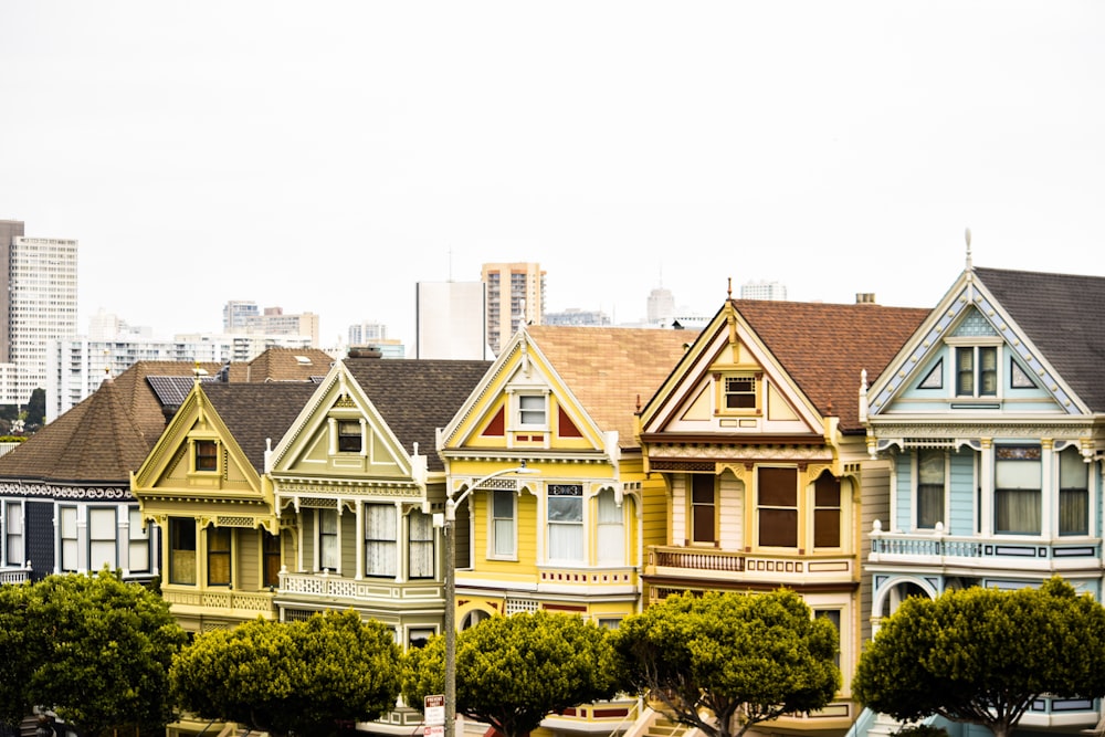 assorted-colored houses under white clouds at daytime