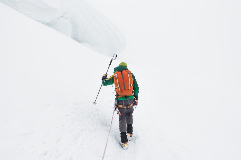 persona che cammina sulla montagna coperta di neve