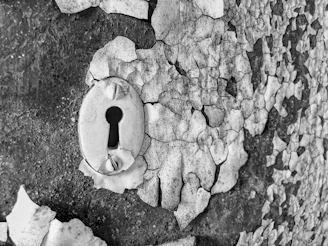 Black and white vintage style image of a secure old-fashioned lock and key on a textured surface.