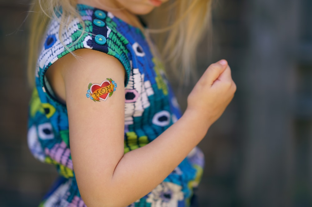 selective focus photo of girl with heart tattoo