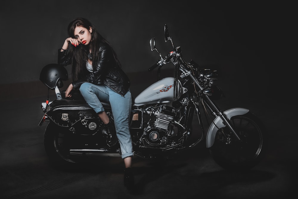 woman sitting on black and white touring motorcycle