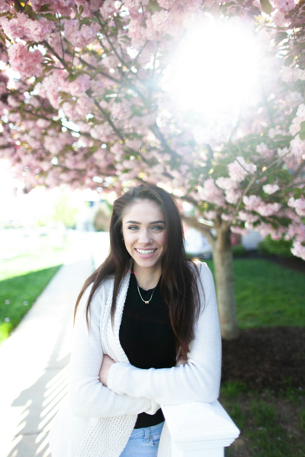 woman standing under cherry blossom tree