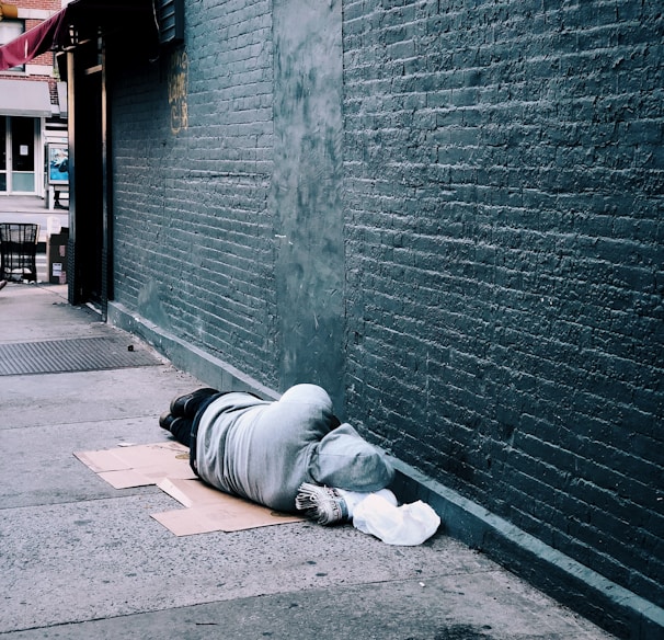 man lying on brown cardboard box