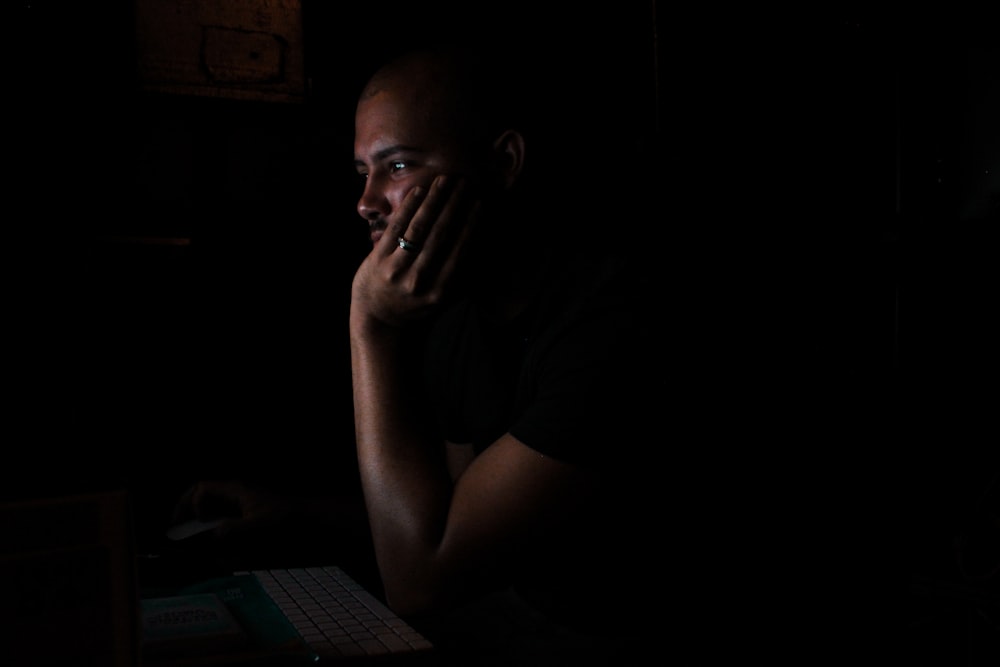 man resting his face on his left hand