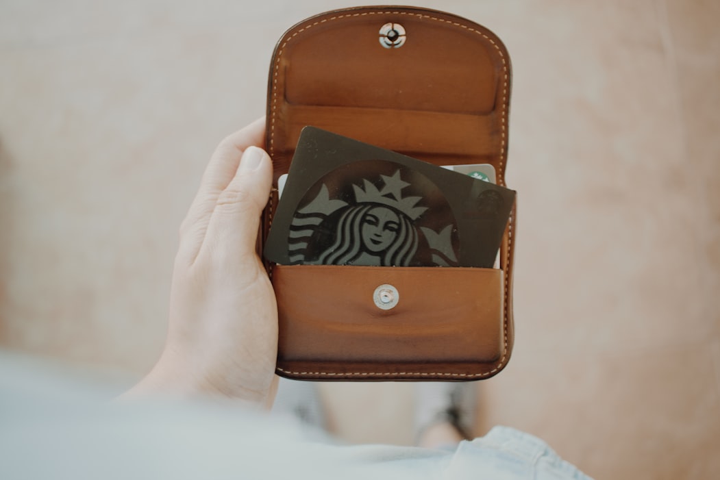 green Starbucks gift card inside brown leather wallet