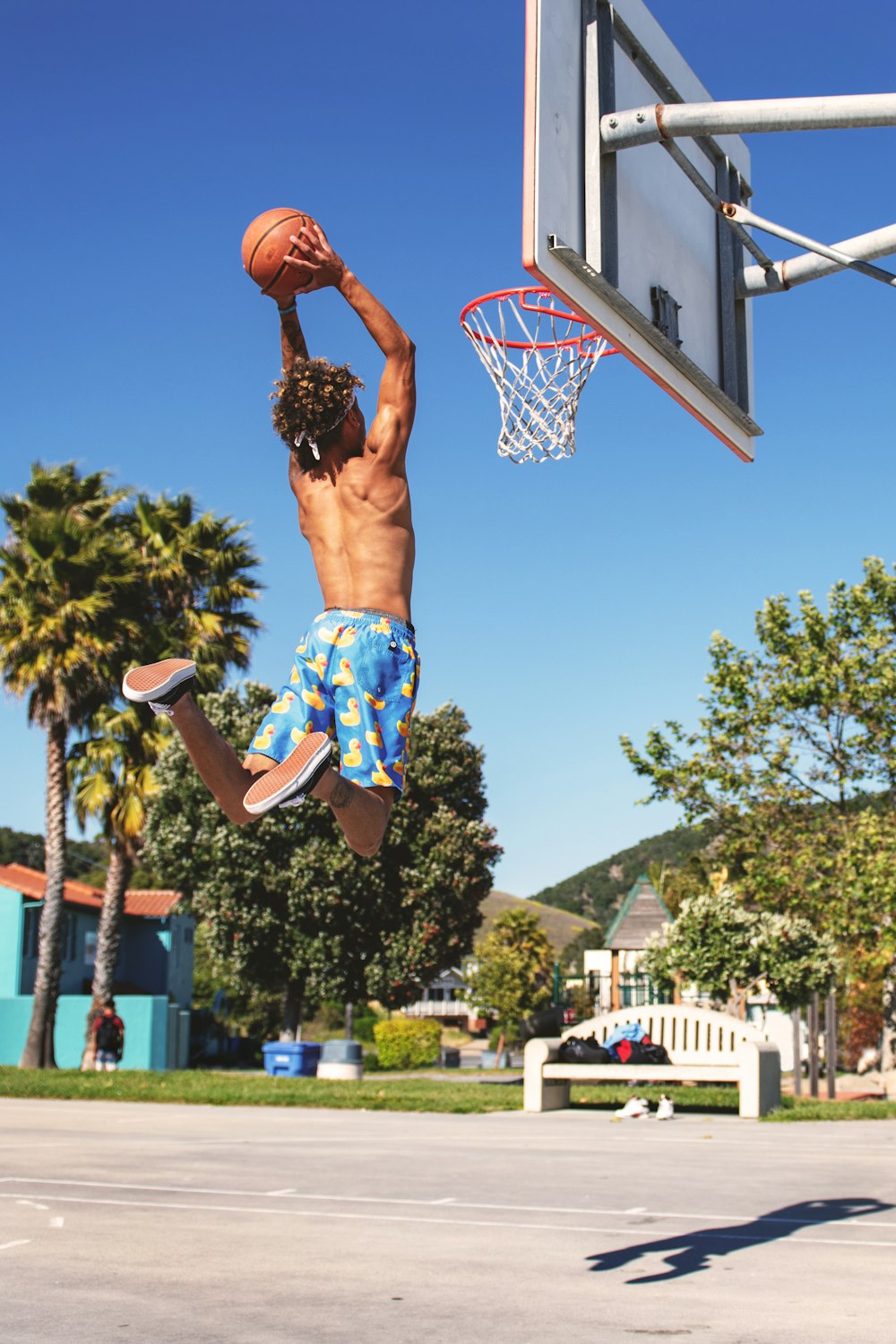 person dunking ball under blue sky during daytime