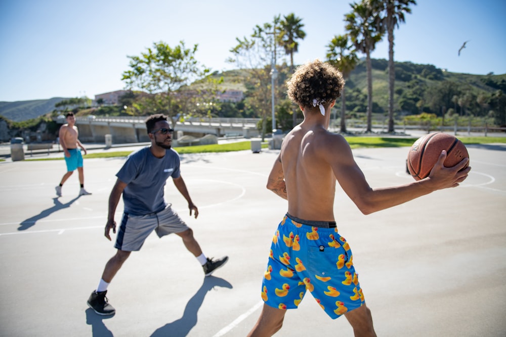 three men playing basketball