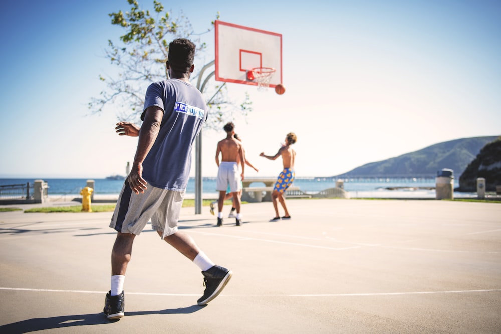 four men playing basketball