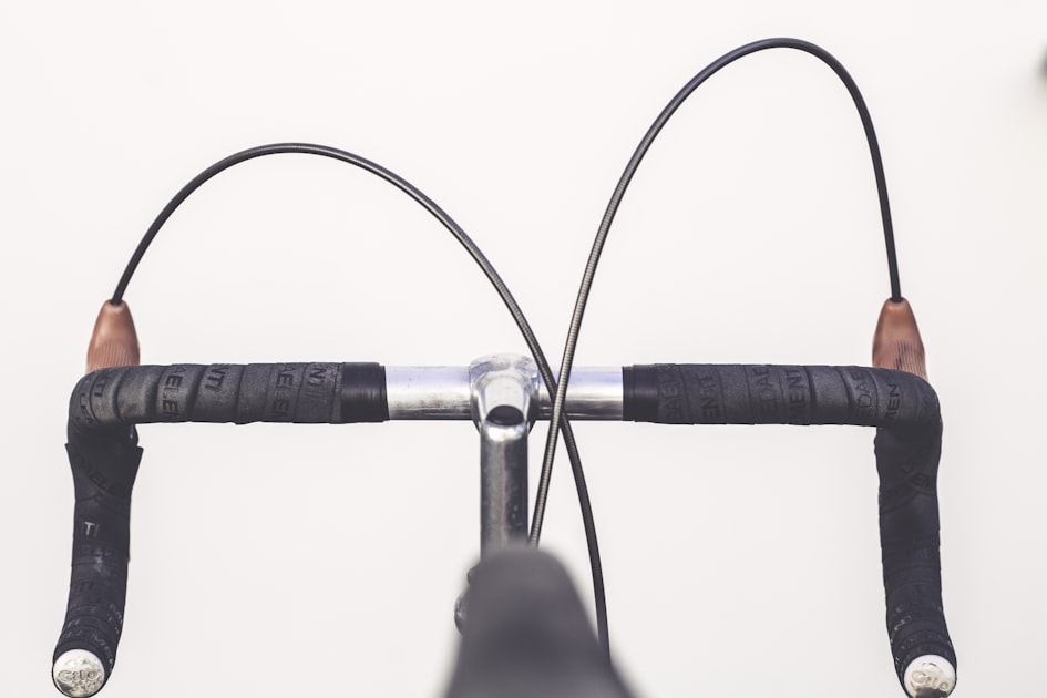 Detalhe em close do guidão drop com fita preta de uma bicicleta de estrada profissional