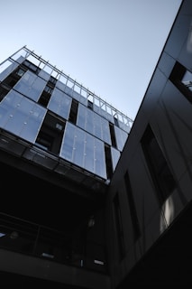 Modern architecture with glass and metal facades. The building features sleek lines and reflective surfaces, creating a contemporary urban aesthetic.