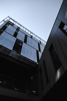 Elegant modern glass facade with sleek metal frames reflecting a sophisticated urban environment.
