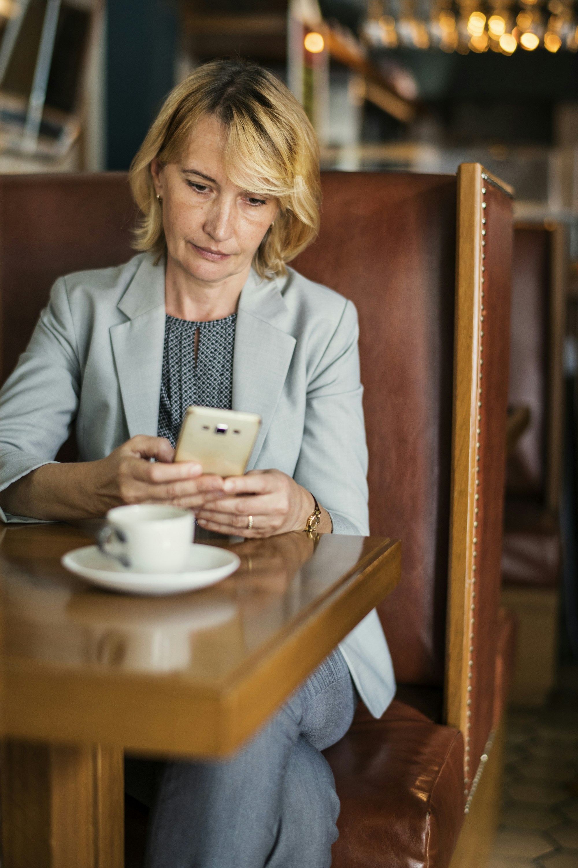 woman using white smartphone on front of table