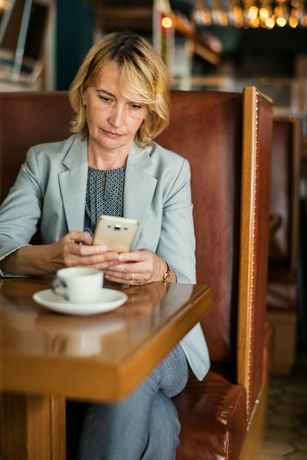 woman using white smartphone on front of table