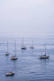 A sailboat anchored in calm blue waters under a clear sky.