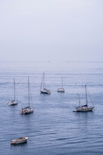 A sailboat anchored in calm blue waters under a clear sky.