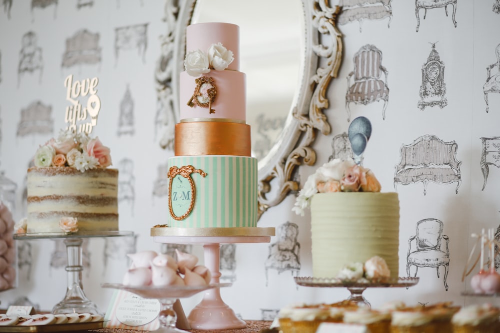 three assorted cakes near white framed mirror