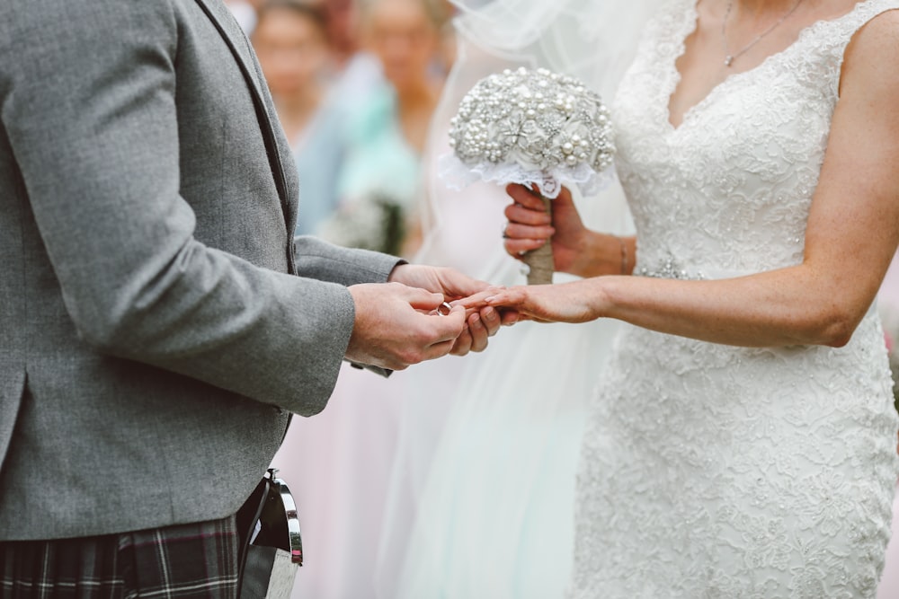Bräutigam steckt Ring an den Finger der Braut