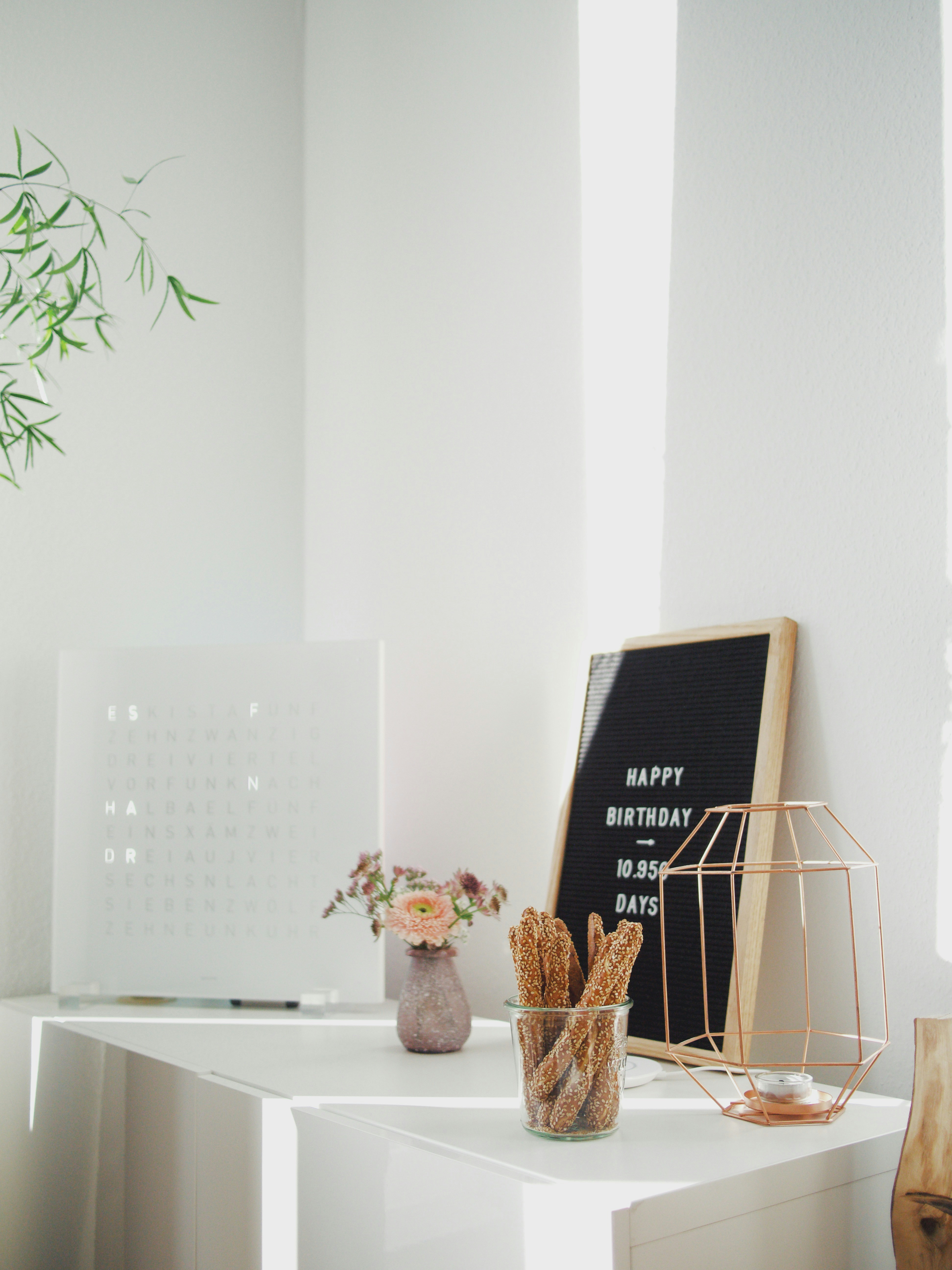 brass-colored wired candle holder on white table