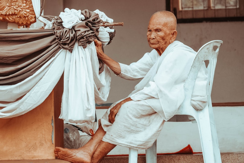 person sitting on white plastic chair