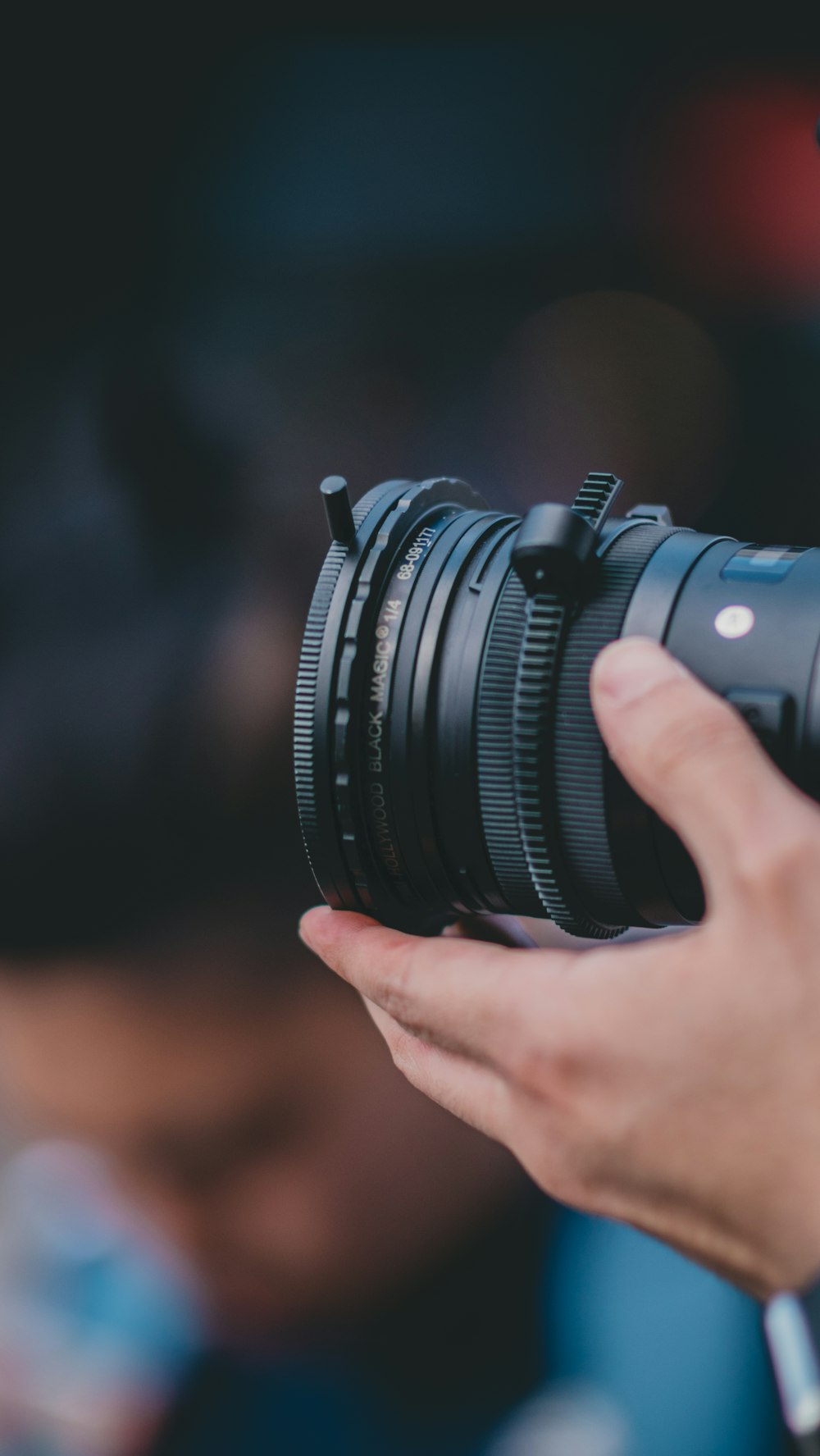 person holding camera lens