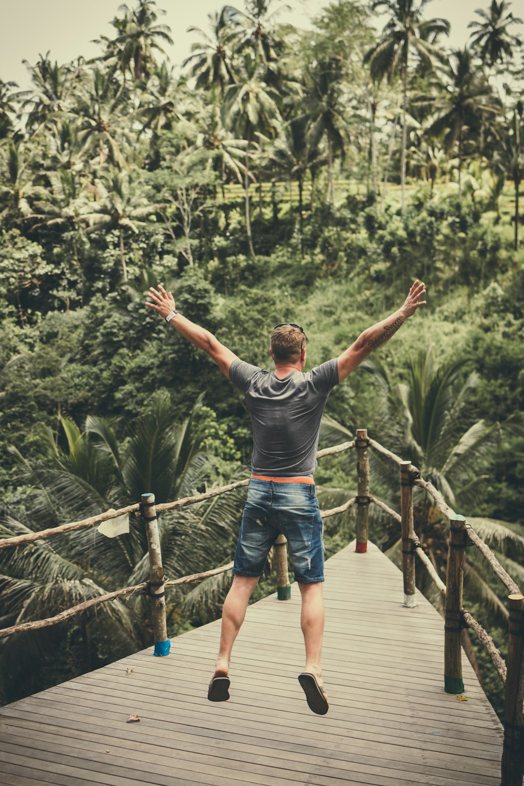 man jumping and raising his arms