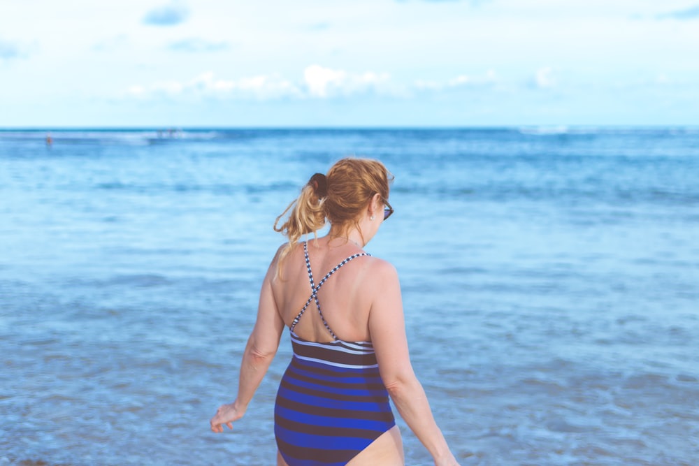 mujer de pie en la orilla del mar