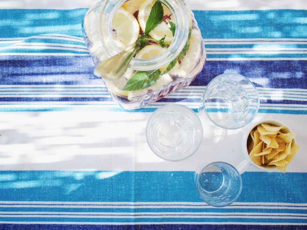 bouteille de jus de citron vert à côté des verres à liqueur sur la table