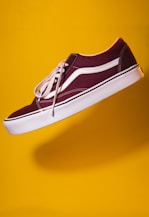 unpaired maroon plimsoll on top of yellow textile