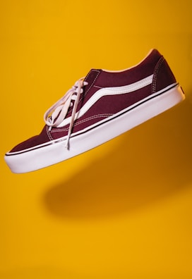 unpaired maroon plimsoll on top of yellow textile