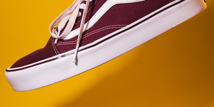 unpaired maroon plimsoll on top of yellow textile