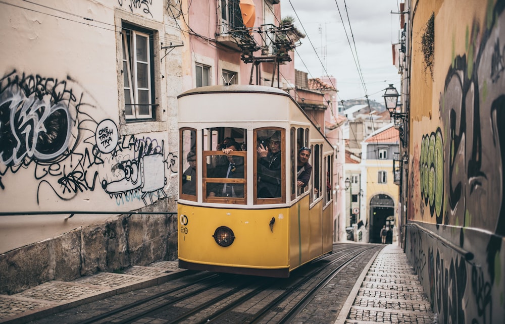 Personas dentro del tranvía entre edificios