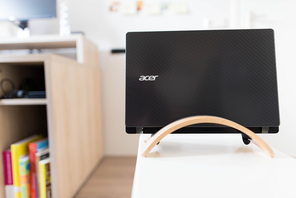 black Acer laptop on white wooden table