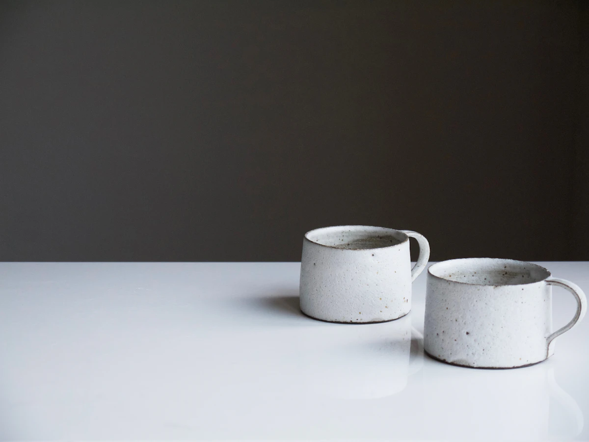 Two ceramic mugs side by side on a white table