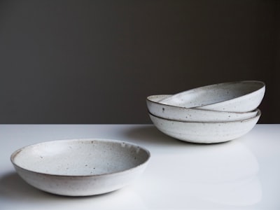 four round white ceramic bowls on white surface ceramic zoom background