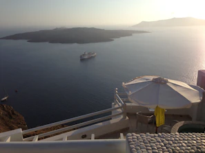 A close-up of a premium cabin balcony overlooking the sparkling sea at golden hour