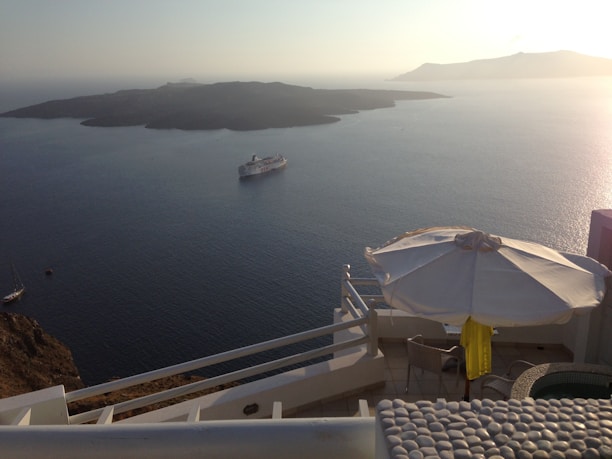 Close-up of a teal and blue cruise ship cabin balcony overlooking calm ocean waters.