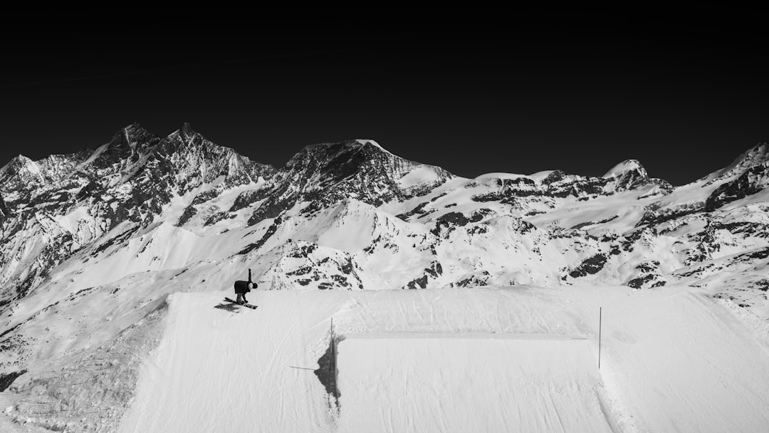 person ice skating on snow covered mountain