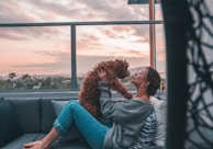 woman holding dog while sitting on sofa