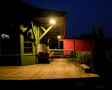 A custom porch with cedar wood accents and subtle gold lighting details at dusk.
