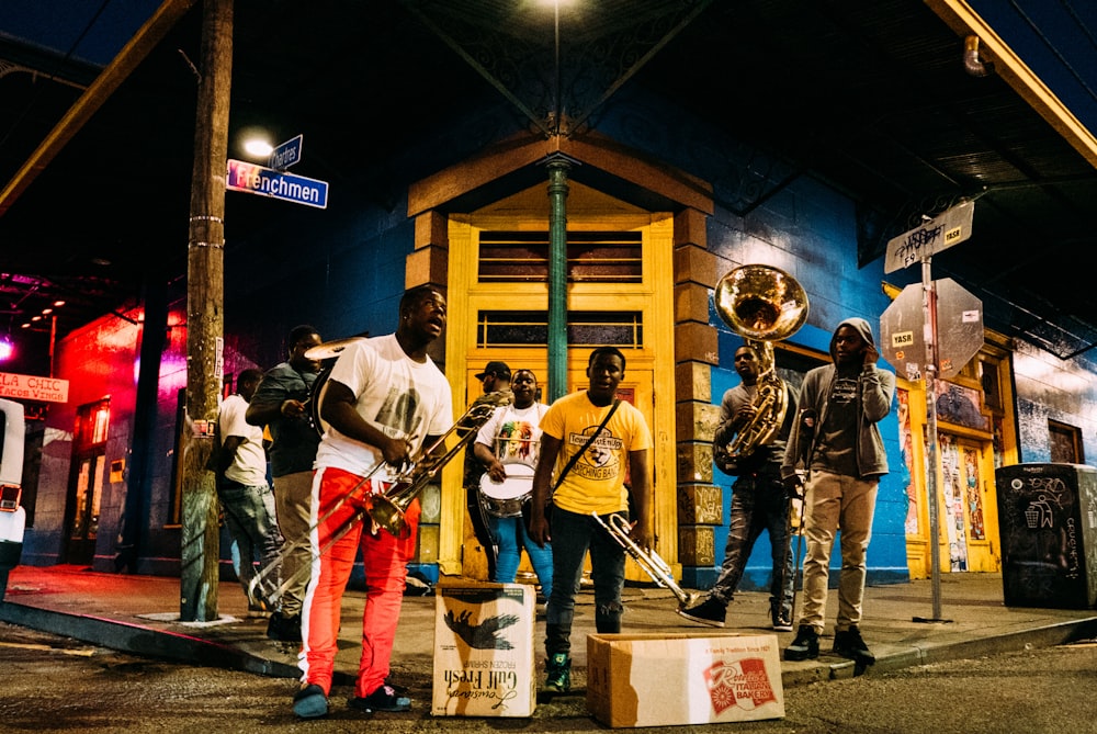pessoas segurando instrumentos musicais enquanto estão na rua durante a noite